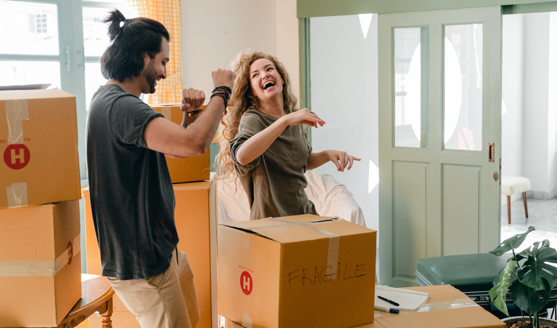 Couple laughing and dancing while unpacking